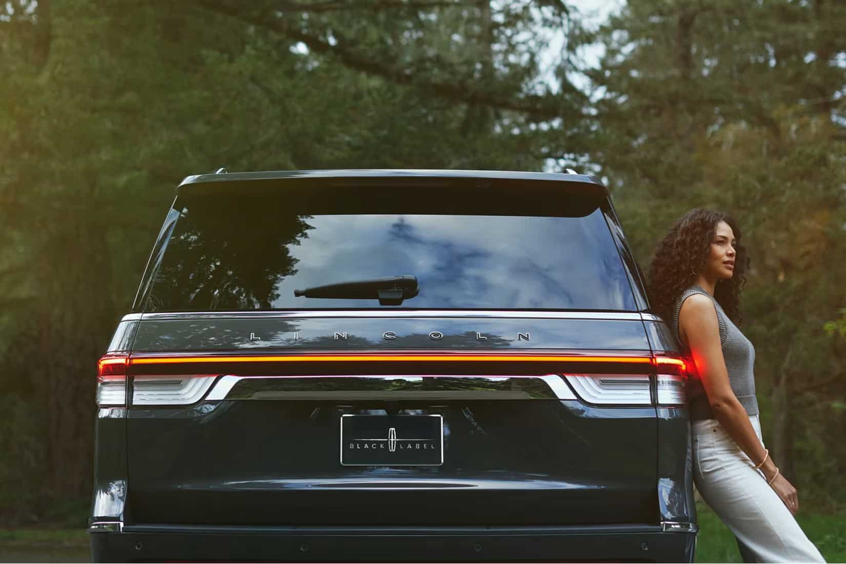 A girl leaning on a pre-owned lincoln car