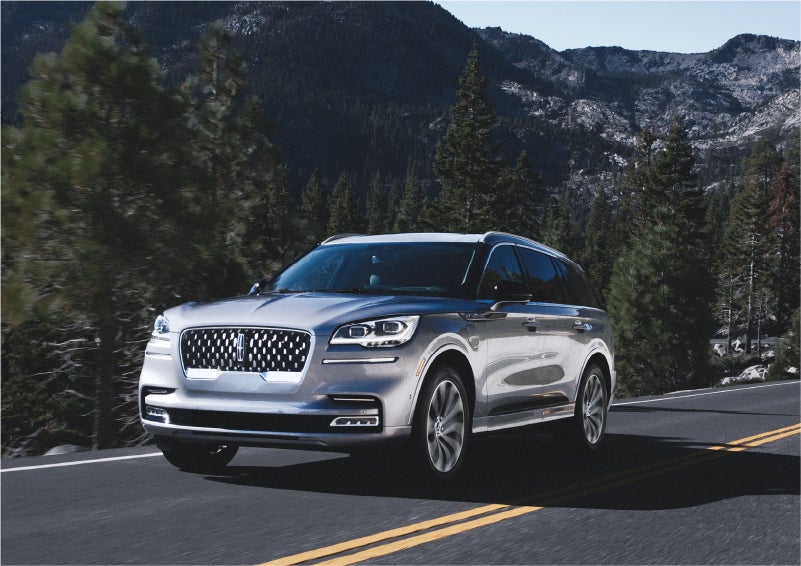 A 2023 Lincoln Aviator® Grand Touring SUV being driven on a winding road to demonstrate the capabilities of all-wheel drive | Rogers Lincoln in Midland TX