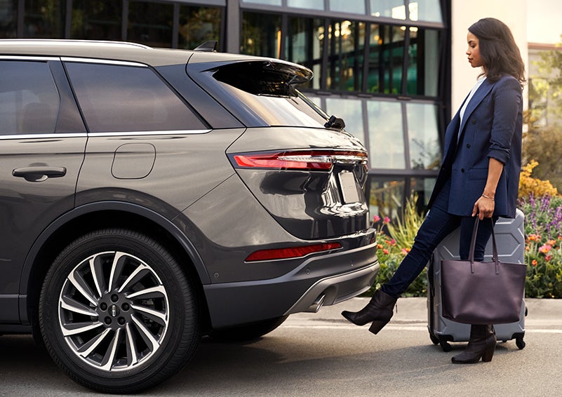 A woman with her hands full uses her foot to activate the available hands-free liftgate. | Rogers Lincoln in Midland TX