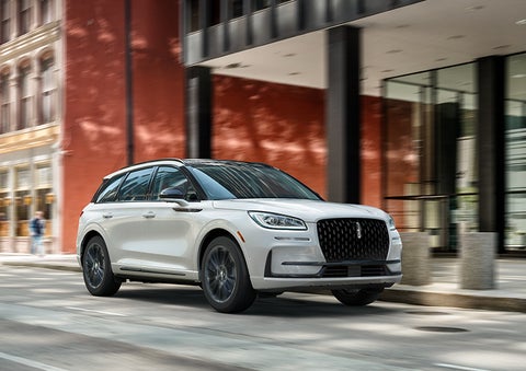 The 2024 Lincoln Corsair® SUV with the Jet Appearance Package and a Pristine White exterior is parked on a city street. | Rogers Lincoln in Midland TX