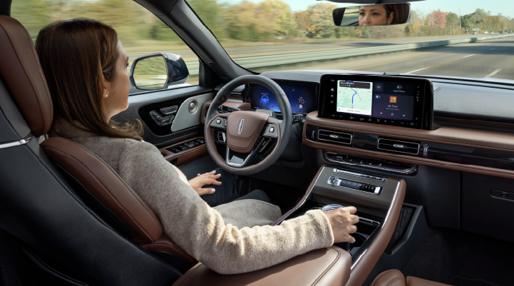 A woman is seen sitting in the driver’s seat of her 2025 Lincoln Aviator® SUV with her hands off the steering wheel. | Rogers Lincoln in Midland TX