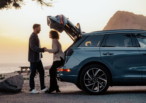A couple share a moment together outside a 2025 Lincoln Corsair® SUV near the open liftgate. | Rogers Lincoln in Midland TX
