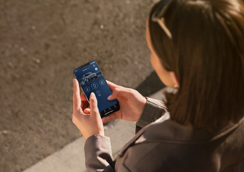 A person is shown interacting with a smartphone to connect to a Lincoln vehicle via the Lincoln Way® App. | Rogers Lincoln in Midland TX