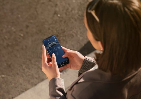 A person is shown interacting with a smartphone to connect to a Lincoln vehicle via the Lincoln Way® App. | Rogers Lincoln in Midland TX