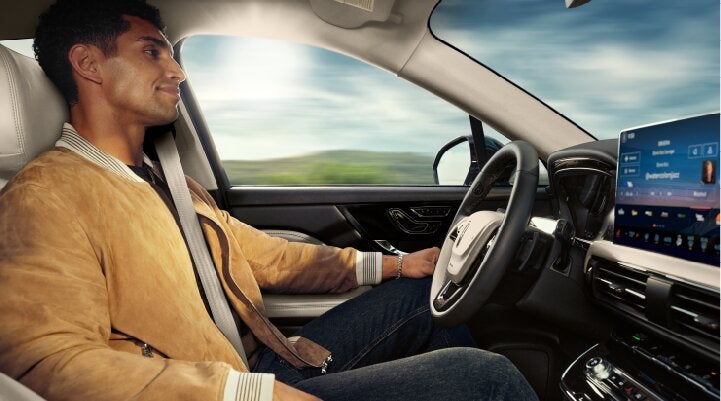 A person is shown using Lincoln BlueCruise hands-free highway driving technology on a divided highway called a Hands-Free Blue Zone. | Rogers Lincoln in Midland TX