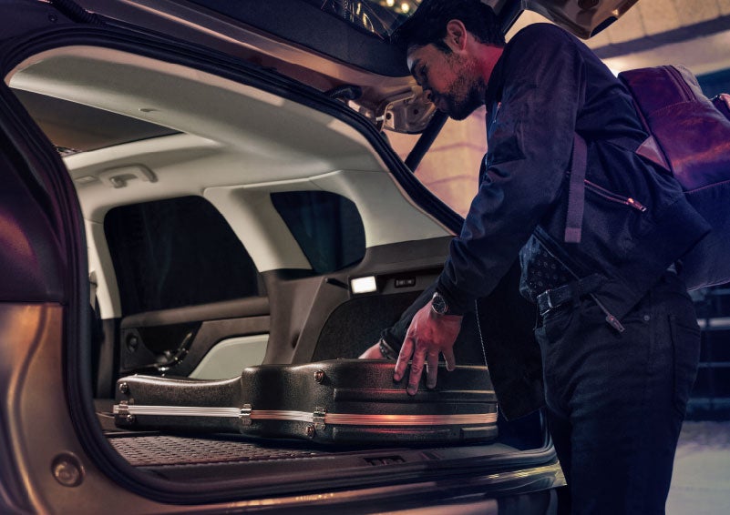 A man is shown loading cargo into the rear of a 2024 Lincoln Corsair® SUV with the second-row seats folded flat. | Rogers Lincoln in Midland TX