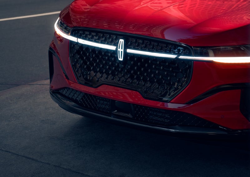 The available front LED light bar and center Lincoln Star logo glow at dusk. | Rogers Lincoln in Midland TX