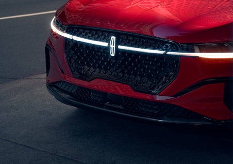 The available front LED light bar and center Lincoln Star logo glow at dusk. | Rogers Lincoln in Midland TX