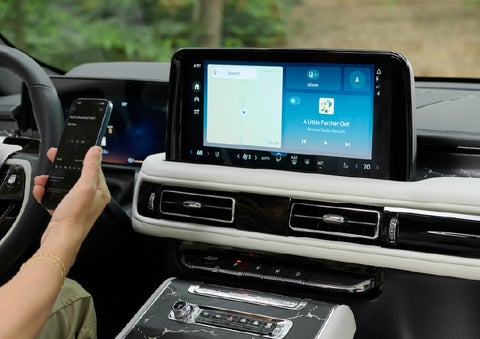 A person pairs thier phone with the center touchscreen of a 2027 Lincoln Aviator® Black Label™ SUV | Rogers Lincoln in Midland TX