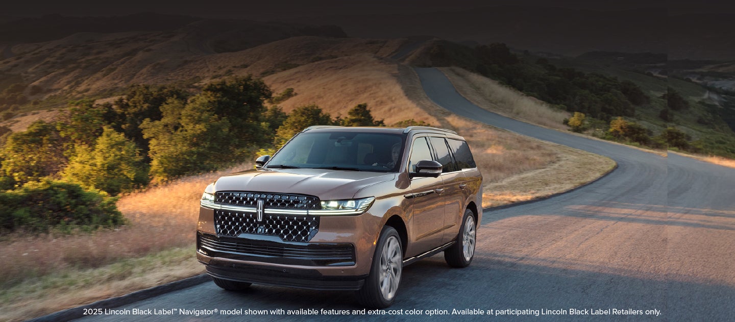 A 2025 Lincoln Navigator® SUV is being driven on a country road.